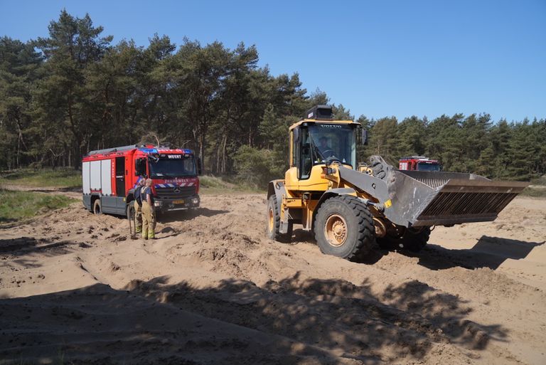 Een shovel moest worden ingezet om de brandweerwagens los te trekken uit het zand (foto: WdG/SQ Vision).