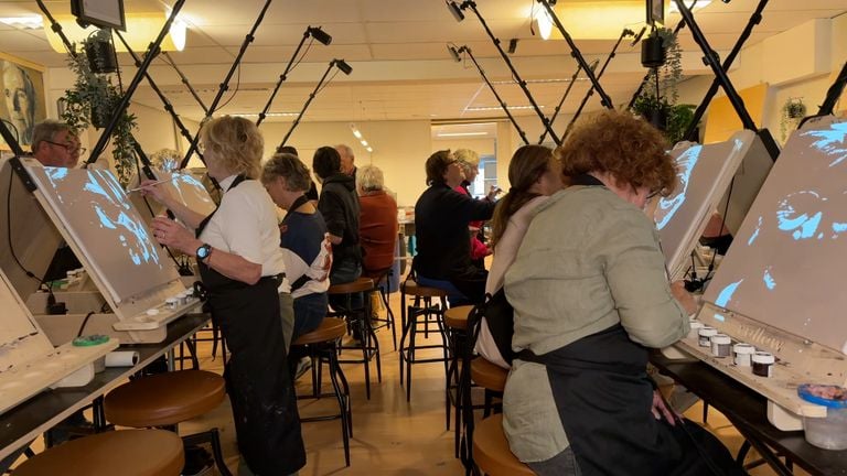 Een foto wordt in lagen opgedeeld en geprojecteerd, zodat deelnemers het portret kunnen overschilderen (foto: Megan Hanegraaf).