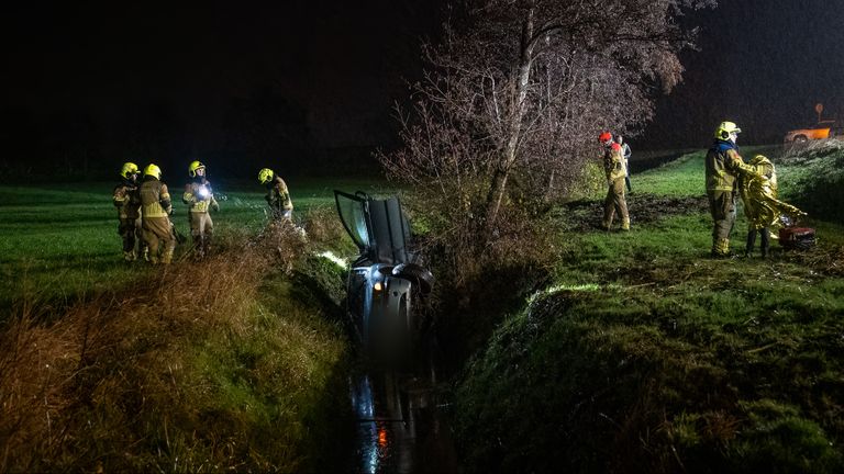 De auto eindigde op zijn kant in een sloot (foto: Iwan van Dun/SQ Vision).