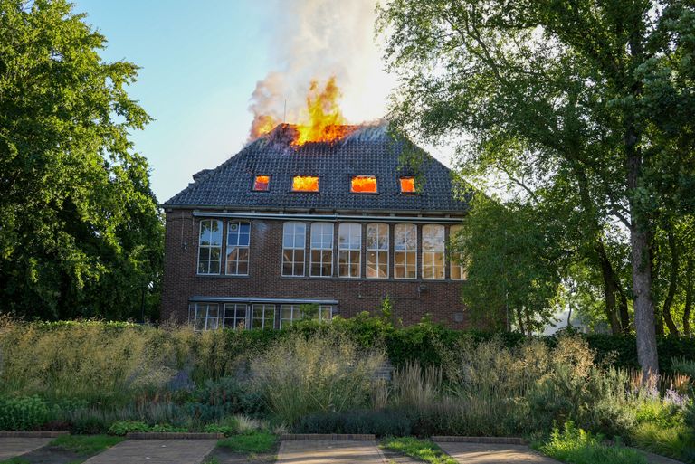 De vlammen slaan uit het dak van het gebouw van het Hooghuis Lyceum in Oss (foto: Gabor Heeres/SQ Vision).