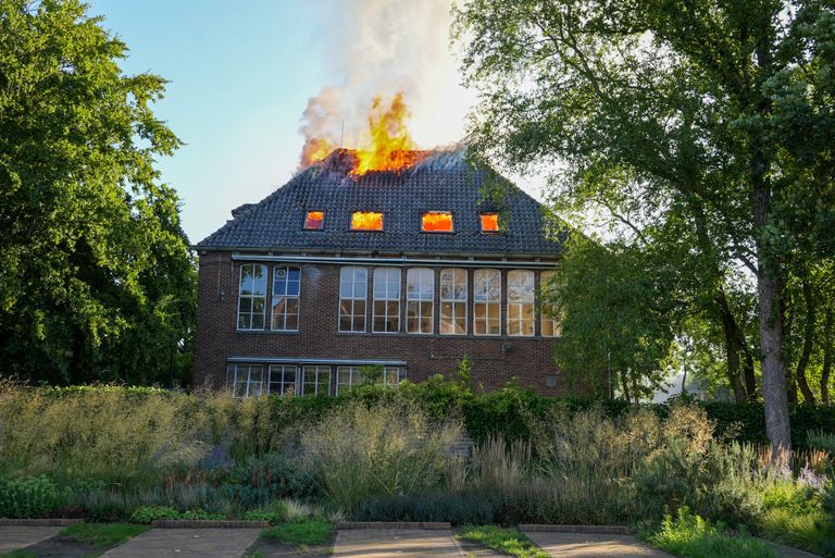 De vlammen slaan uit het dak van het gebouw van het Hooghuis Lyceum in Oss (foto: Gabor Heeres/SQ Vision).