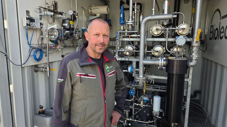 Boer Jos bij de gasopwekinstallatie, de container waarin het gas klaar wordt gemaakt voor de consument (foto: Noël van Hooft).