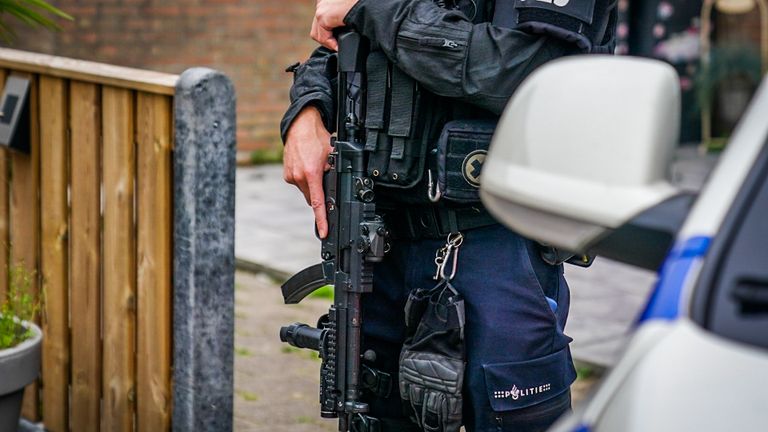 Ook vrijdagochtend staan er zwaarbewapende agenten bij de garageboxen aan de Italiëlaan in Eindhoven (foto: Sem van Rijssel/SQ Vision).