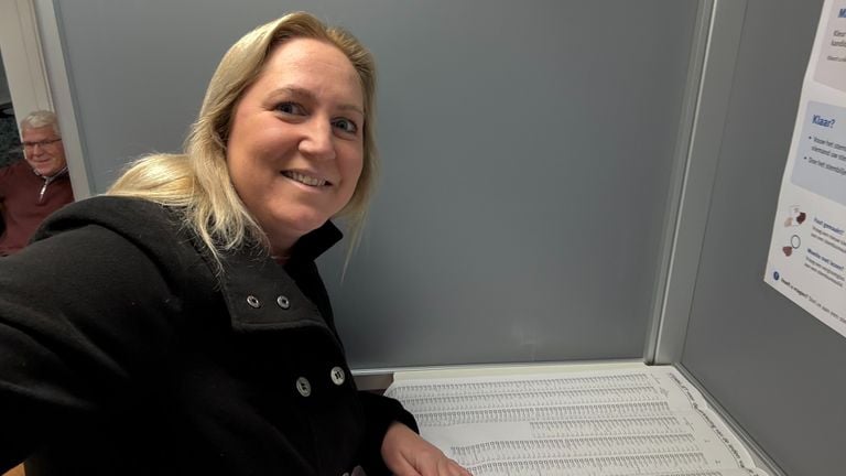 Imke staat met een grote glimlach in het stemhokje (foto: Imke van de Laar).