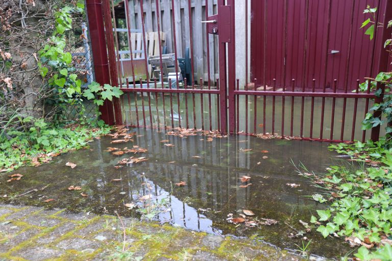 Door de gesprongen waterleiding in Nuenen kwamen tuinen en schuren blank te staan (foto: Arno van der Linden/SQ Vision).