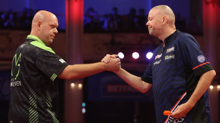 Michael van Gerwen (links) en Raymond van Barneveld schudden elkaar de hand (foto: ANP).