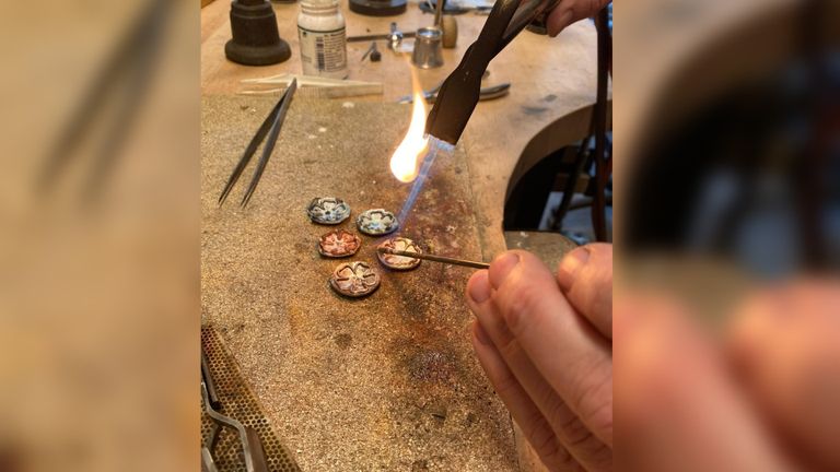 Bregje druk bezig met het solderen van de roosjes voor de ambtsketen