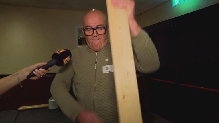 Met een lange plank stamt Rene de biljetten aan (beeld: Omroep Brabant).