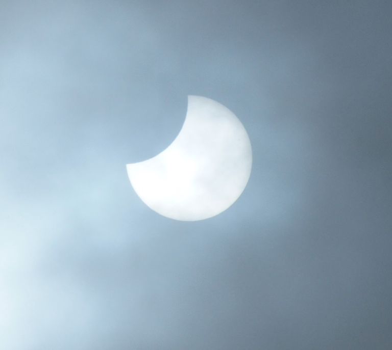 Achter de wolken schijnt de gedeeltelijke zonsverduistering (foto:Dini Reijnen)