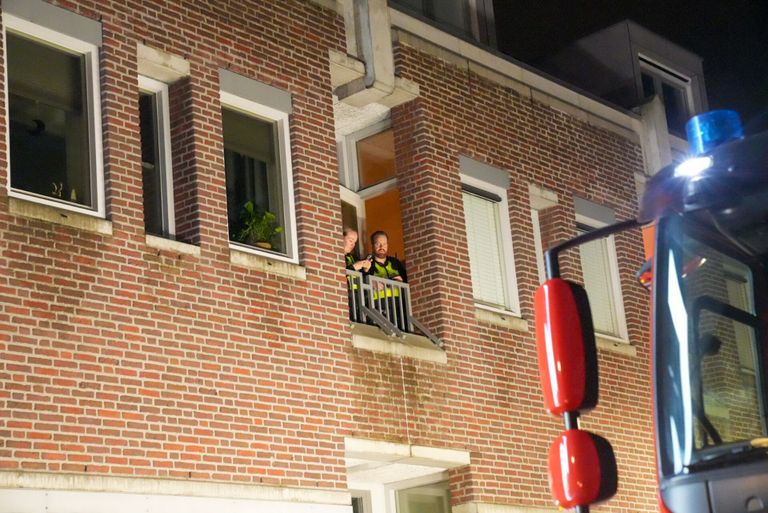 Het slot van de deur van het appartement in Deurne ging niet meer open, dus zaten de agenten vast (foto: Harrie Grijseels/SQ Vision).