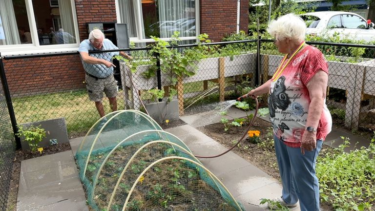 Peter geeft Mieke met dementie aanwijzingen in de moestuin.