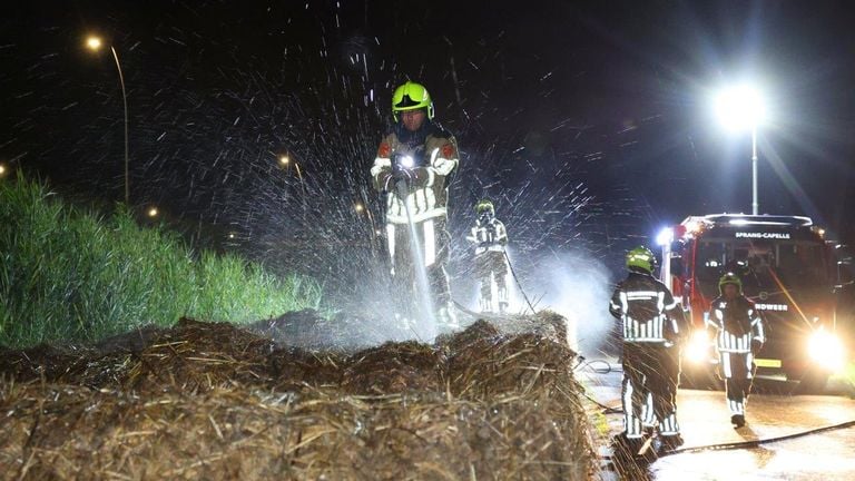 De brandweer bluste de hooibalen in Waalwijk (foto: Bart Meesters).