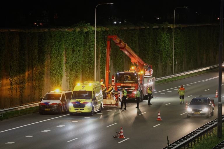 De vrouw werd met een hoogwerker van de geluidswal langs de A2 gehaald (foto: Sander van Gils/SQ Vision).