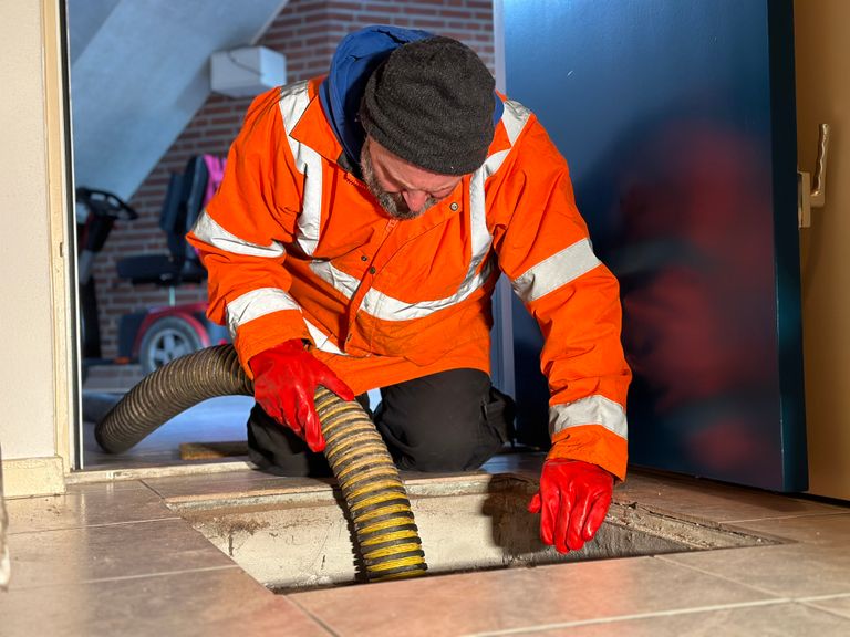 Henri maakt lange dagen om kelders en kruipruimten watervrij te krijgen (foto: Omroep Brabant).