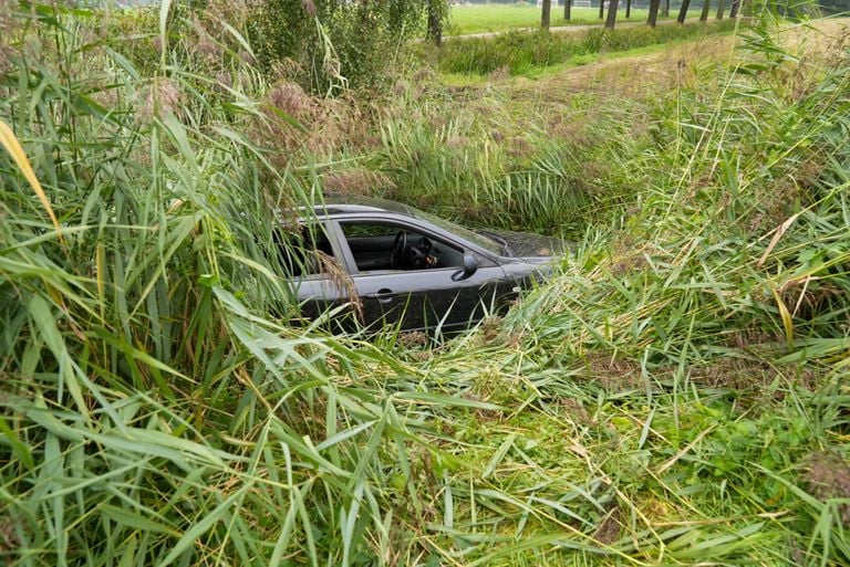 Hoe de auto in Aarle-Rixtel in een sloot kon belanden, wordt onderzocht (foto: Harrie Grijseels/SQ Vision).