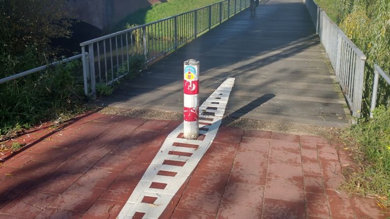 De wit geribbelde markering op de straat en de kleur van het paaltje zijn nodig om fietsers te waarschuwen (foto: Fietsersbond Den Bosch)