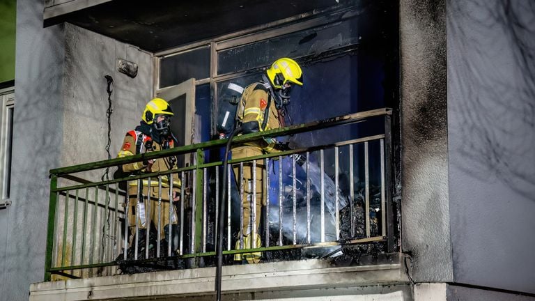 De brandweer doofde het vuur op het balkon van de flat aan de Mahlerstraat in Tilburg (foto: Jack Brekelmans/SQ Vision).