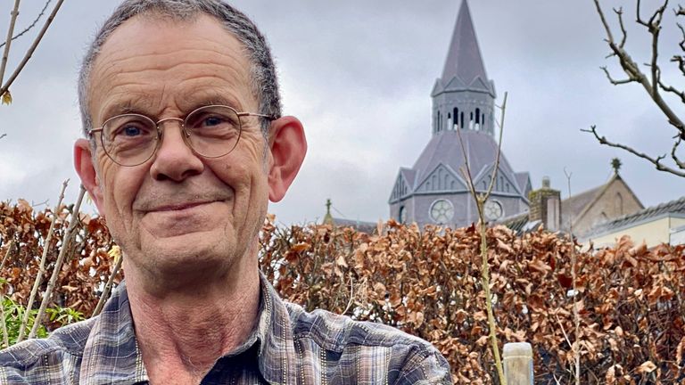 Johan de Boer en achter hem de Petruskerk waar de slechtvalken nestelen (foto: Jan Peels)