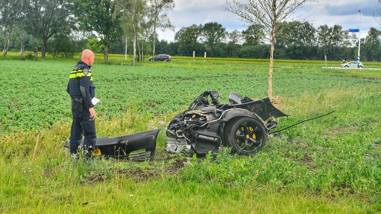 Een agent bekijkt de wrakstukken van de auto (foto: SQVision Rico Vogels )