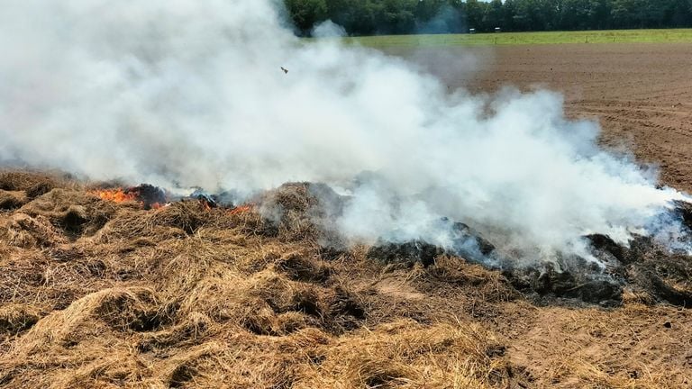 De berg hooi zou voor de derde keer in brand staan (foto: Dimitri Verbeek).