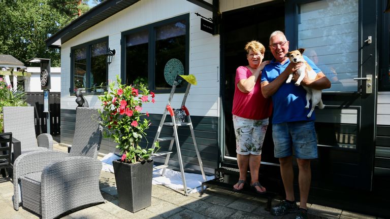 Bernadette en Leo voor hun nieuwe chalet, wat Leo net voorziet van een nieuw laagje verf.