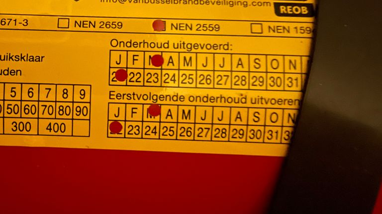 De sticker op de brandblusser.