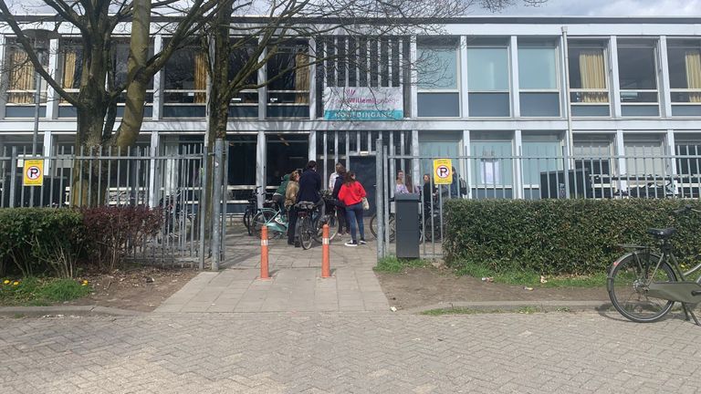 Een groepje leerlingen en docenten moet buiten nog even bijkomen van de schrik (foto: Carlijn Kösters).