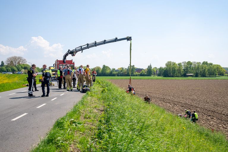 Met een kraan moest de motorrijder naar boven worden gehaald (foto: SQ Vision/Iwan van Dun).