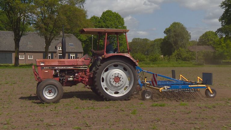 Boer John op zijn trekker met wiedeg.