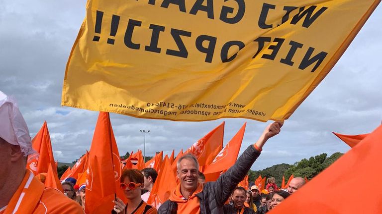 Vader Bayings valt op met zijn gele vlag tussen al dat oranje.