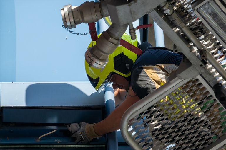 Een brandweerman redt de duif uit zijn benarde positie (foto: Iwan van Dun/SQ Vision).