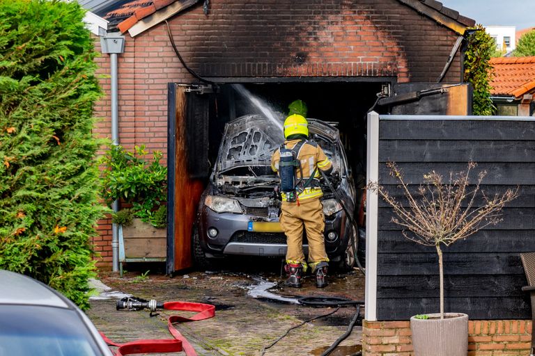 De brandweer blust een garagebrand in Sleeuwijk. (foto Jurgen Versteeg / SQ Vision) 