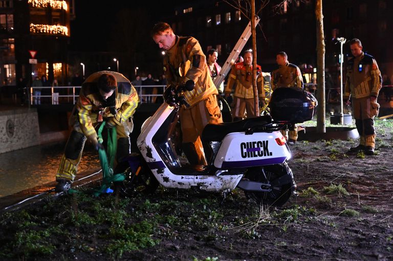 Brandweerlieden visten de scooter uit het water. 