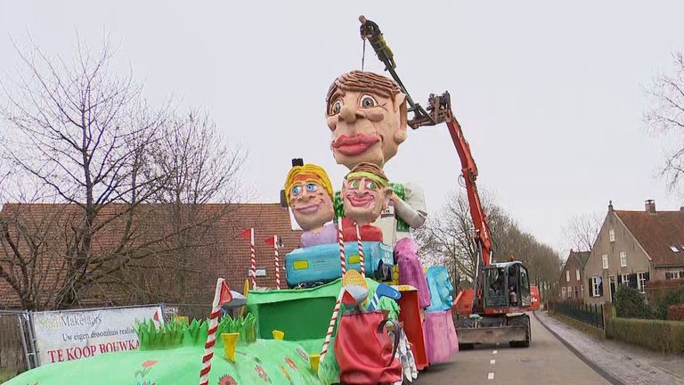 Een van de wagenbouwers doet de 'finishing touch' voor de optocht. 