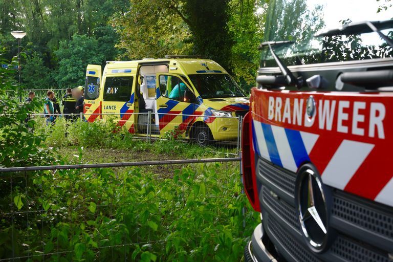 Een man die in Sint-Michielsgestel in de Dommel terecht was gekomen, werd door ambulancemedewerkers en de politie opgevangen (foto: Sander van Gils/SQ Vision).