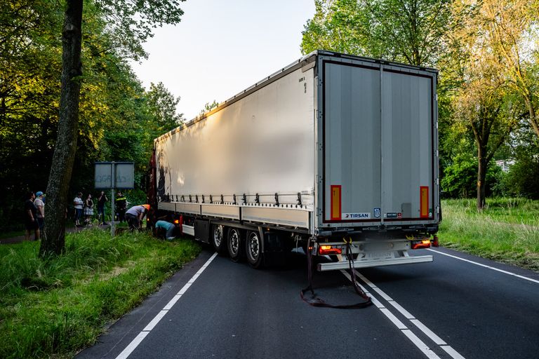 Bergingsmedewerkers proberen de vrachtauto los te trekken (foto: SQ Vision/Jack Brekelmans).