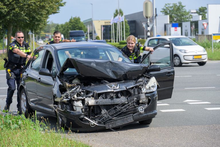 Agenten duwen een van de verongelukte auto's aan de kant (foto: Tom van de Put/SQ Vision).
