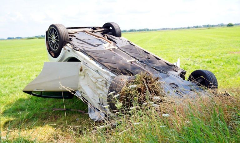 De auto raakte op de kop in het weiland (foto: Bart Meesters/SQ Vision).