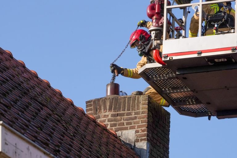 De brandweer maakt de schoorsteen schoon, nadat het vuur was geblust (foto: Harrie Grijseels/SQ Vision)