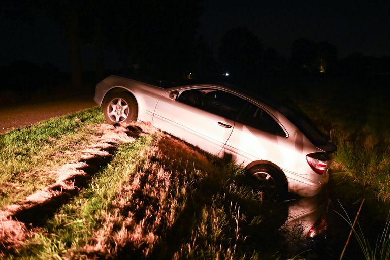 De auto hangt in de sloot langs een van de buitenwegen van Liessel (foto: Walter van Bussel/SQ Vison)