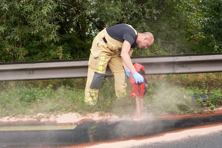 De brandweer probeert te voorkomen dat de diesel de rivier inloopt (foto: Harrie Grijseels/SQ Vision).