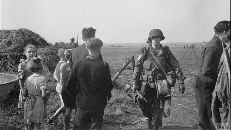 Amerikaanse soldaat tussen inwoners Son op de heide (foto: NIMH)