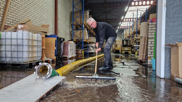 Medewerkers proberen met man en macht de loods droog te krijgen (foto: Noël van Hooft).