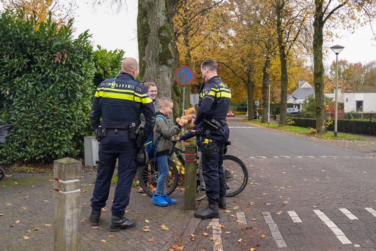 De politie geeft kinderen een knuffelbeer als troost (foto: Harrie Grijseels/SQ Vision).