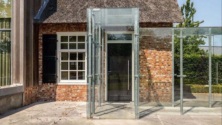 De glazen doorgang van het woonhuis naar de garage (foto: Van Baarle Makelaardij).
