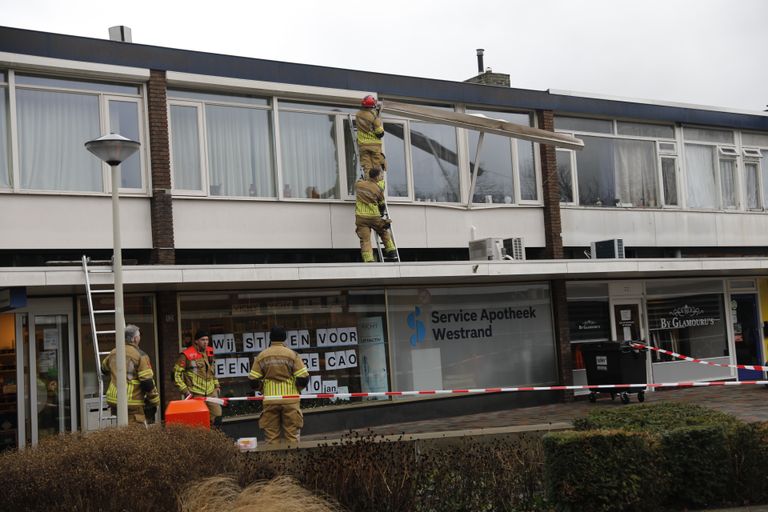 De brandweer is druk in de weer met het losse rolluik (Foto: Christian Traets / SQ Vision).