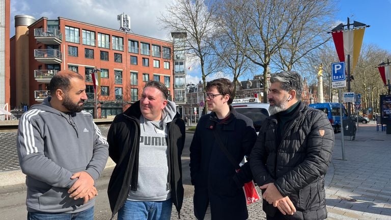 Ismail in overleg met twee collega's en een commissielid van de SP bij een taxistandplaats in Den Bosch (foto: Megan Hanegraaf).