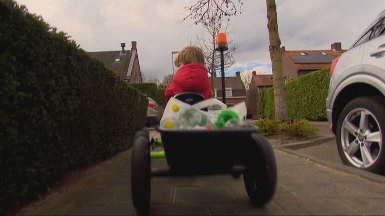 Sjors rijdt met zijn skelter vol statiegeldflessen door Riel (foto: Jan Peels)