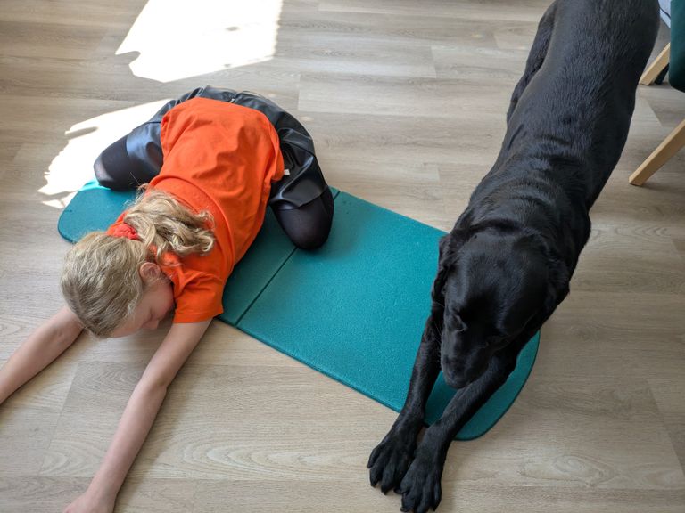 Hond en kind in yogapose om de dag soepel door te komen (foto: Monica).