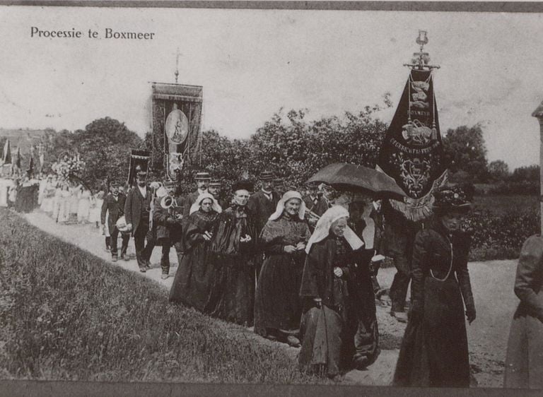 Een processie trekt door de Boxmeerse velden in de volle zon. Voorop dames in het lang en met Brabantse mutsen, vervolgens Utile Dulci met het vaandel en dan bruidjes en de rest van de stoet.  (foto: BHIC)